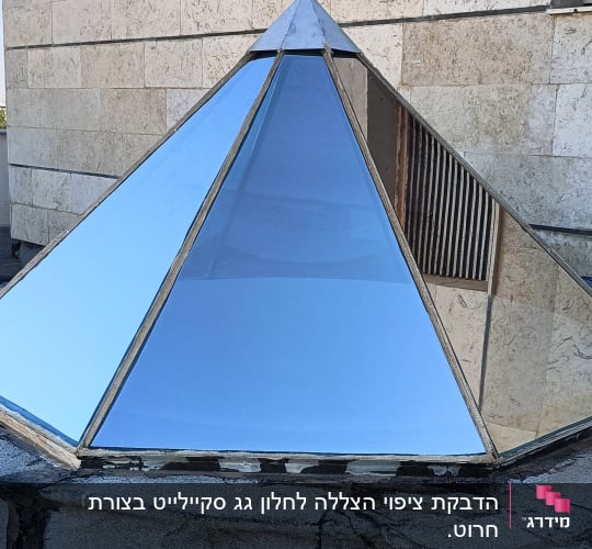 פירמידת זכוכית על גג עם צינורות וחוט חשמל